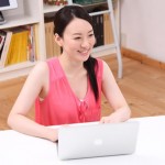 パソコンの前で笑顔の女性