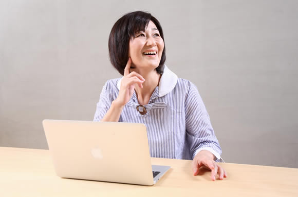 パソコンの前で笑顔の女性